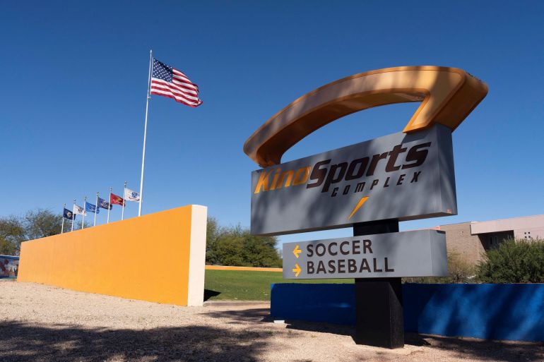 The American flag flutters near a sign pointing to the soccer stadium at Kino Sports Complex, where the Iranian men’s soccer team is scheduled to practice for the FIFA World Cup, in Tucson, Arizona