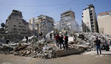 People walk amidst debris at the site of an Israeli strike in Zuqaq al-Blat district in central Beirut, Lebanon.