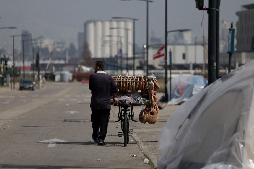 A man carries bread on his bike, following an escalation between Hezbollah and Israel amid the US-Israeli war with Iran, in Beirut, Lebanon, on March 19, 2026.