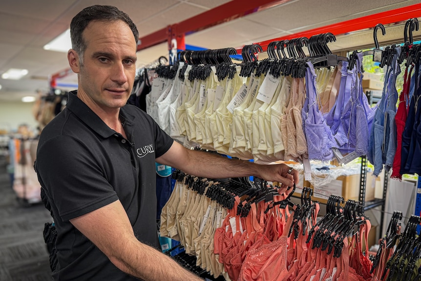 A man holds onto some bras.