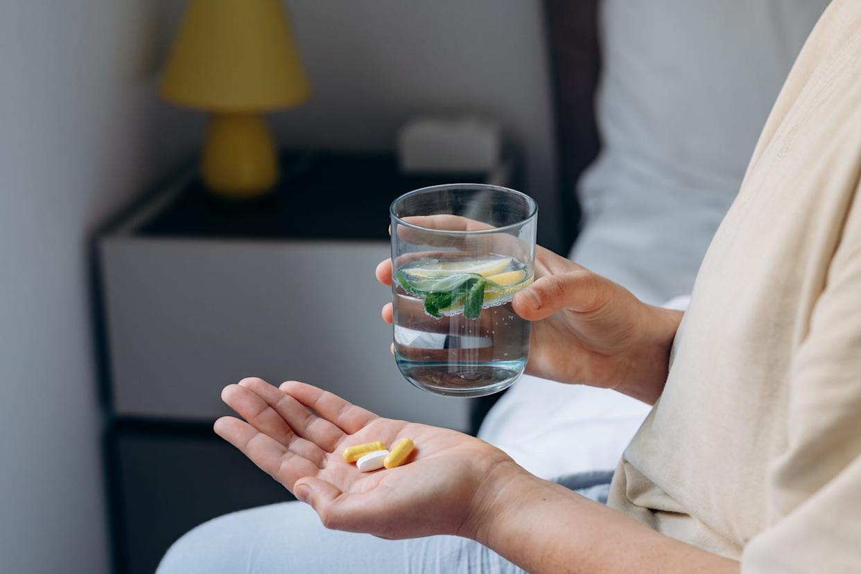 woman taking her vitamins and supplements, variety of pills and capsules
