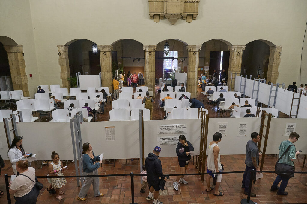 Voters in early voting at Honolulu Hale on King Street in Honolulu were met with torrential downpours as they drove through the election only lane that had been set aside and coned to allow drivers to either hand off their ballots to Poll workers or drop them into several Ballot boxes placed and manned along King Street. (David Croxford/Civil Beat/2024)
