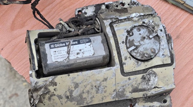 A close up of missile debris, with a damaged address sticker from Globe Motors Inc, saying "Made in the USA"