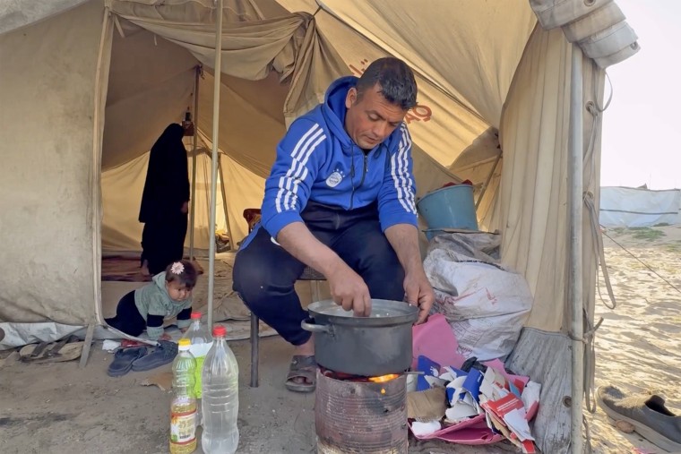 Raed Abu Ouda outside his family's tent, with his wife and daughter inside. 