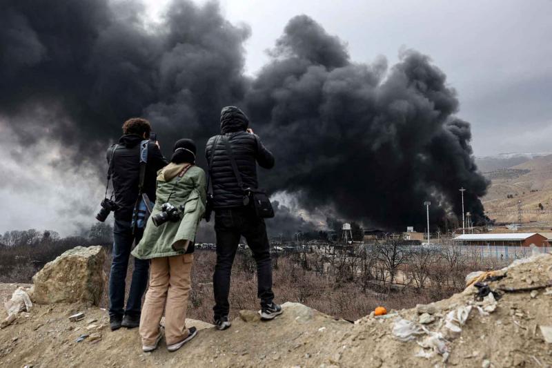 People record smoke rising after a reported strike on Shahran fuel tanks in Tehran, March 8, 2026.