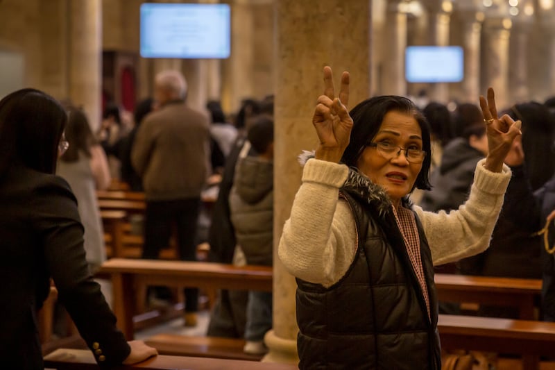 A woman makes peace signs during Mass in St Joseph Catholic Church in Monot. Photograph: Sally Hayden