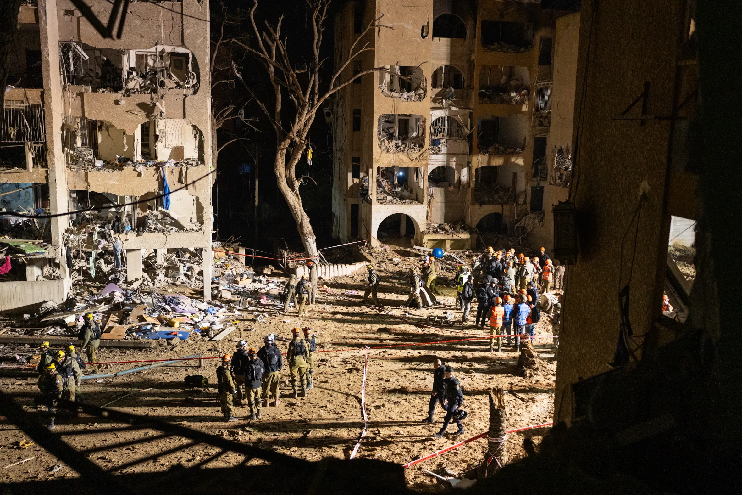 Emergency workers gather at the site of a missile strike that damaged buildings and created debris in Arad, Israel.