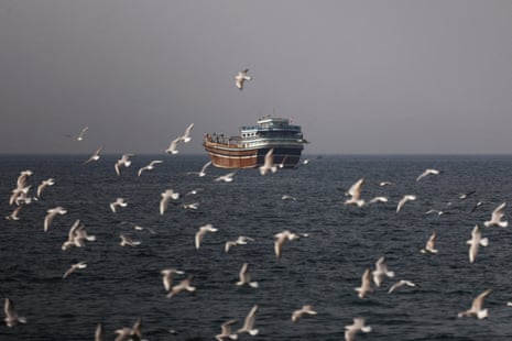 Birds fly near a boat in the Strait of Hormuz amid the US-Israeli conflict with Iran, as seen from Musandam, Oman, 2 March, 2026.
