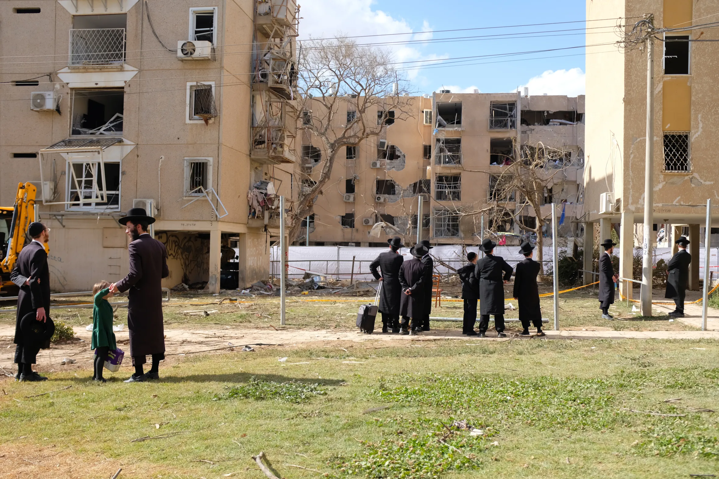 Residents inspect the damage of a missile strike in Arad.