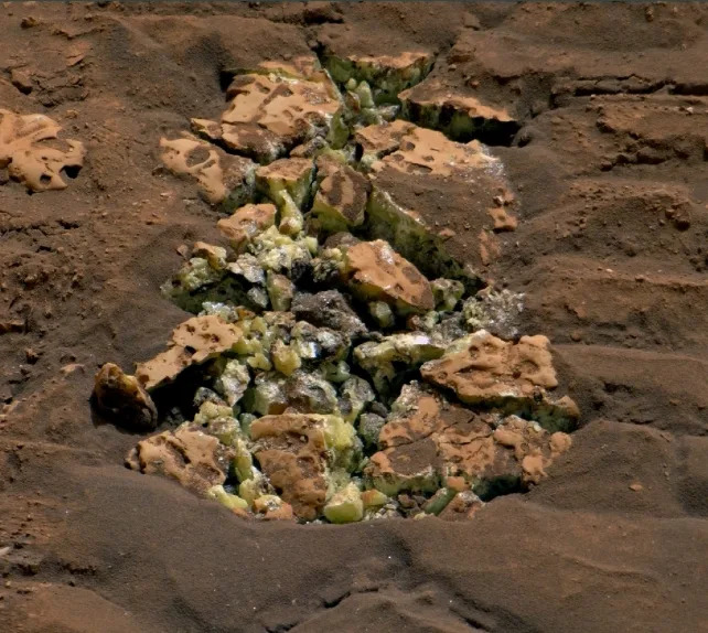 Yellow crystals that were revealed after NASA's Curiosity happened to drive over a rock and crack it open