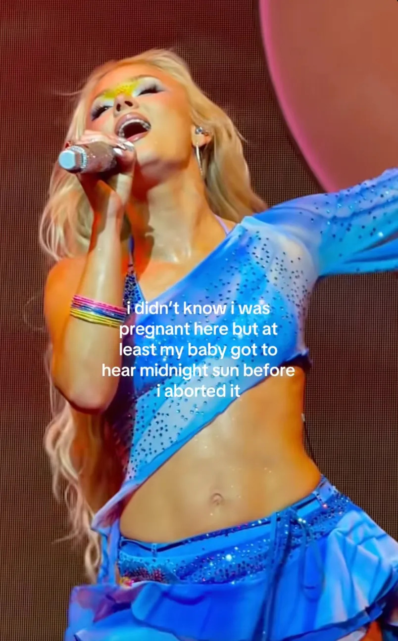 Zara Larsson in a sequin blue performance outfit singing on stage. Text overlay reads, “i didn’t know i was pregnant here but at least my baby got to hear midnight sun before I aborted it.”