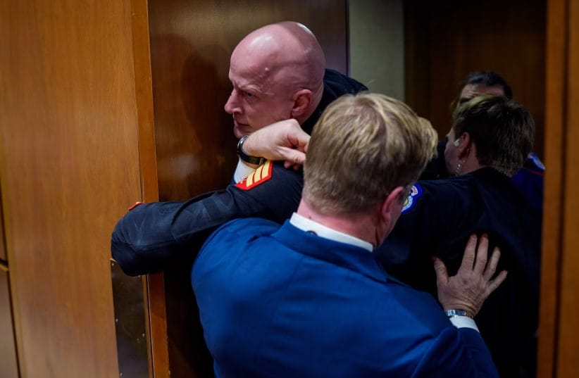 Brian McGinnis gets stuck in a door, injuring his arm, as Sen. Tim Sheehy and US Capitol Police officers attempt to remove him from a Senate Armed Services Subcommittee hearing on Capitol Hill on March 4, 2026 in Washington, DC.