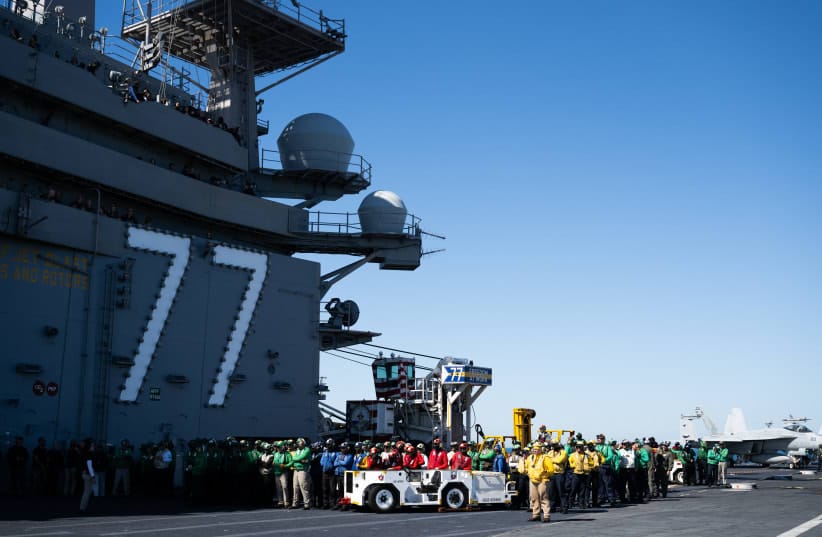 Crew members look on as US President Donald Trump and First Lady Melania Trump visit the USS George H.W. Bush aircraft carrier which is out at sea near Norfolk, Virginia, October 5, 2025.