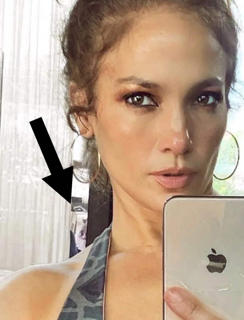 Person poses for a selfie in a camo sports bra, showcasing their fitness, in a room with exercise equipment