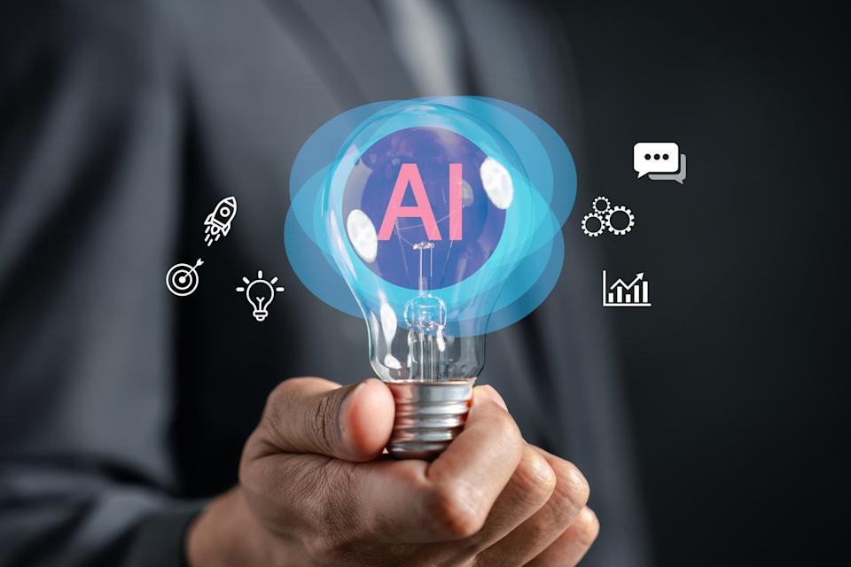 A hand holding a bulb with the word AI in it. 