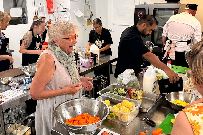 People make food in a commercial kitchen.