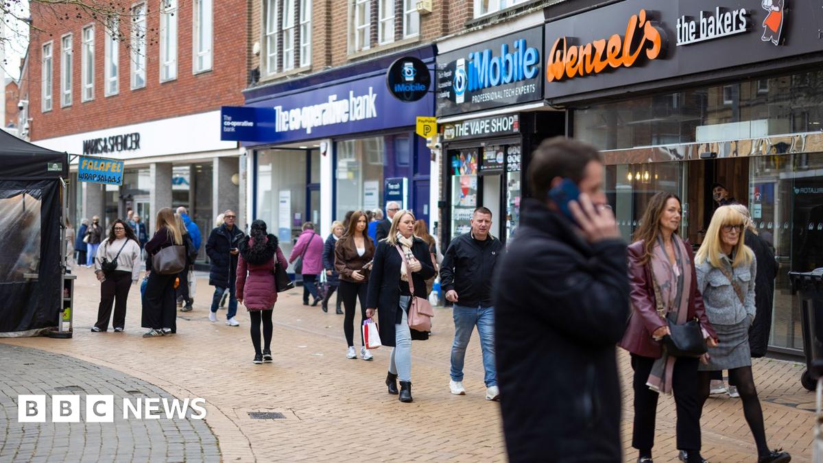 A scene of a high street in Chelmsford earlier this week shows people walking down the street and a man on his phone with shops lining the street.