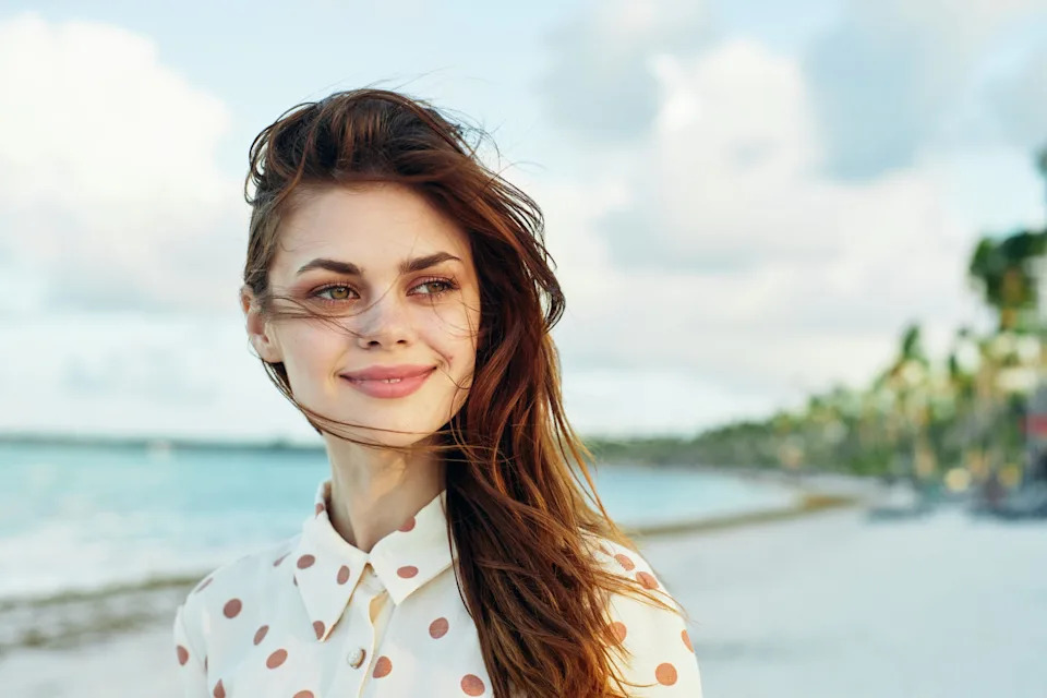 Young friendly woman taking a walk alone on the beach.