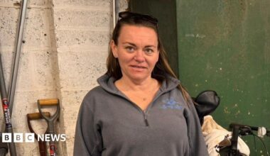 Rachel Douglas is a woman in her 40s wearing a grey top and has long brown hair. She is standing in front of a green tank - on the top is a guage which has an arrow pointing to empty