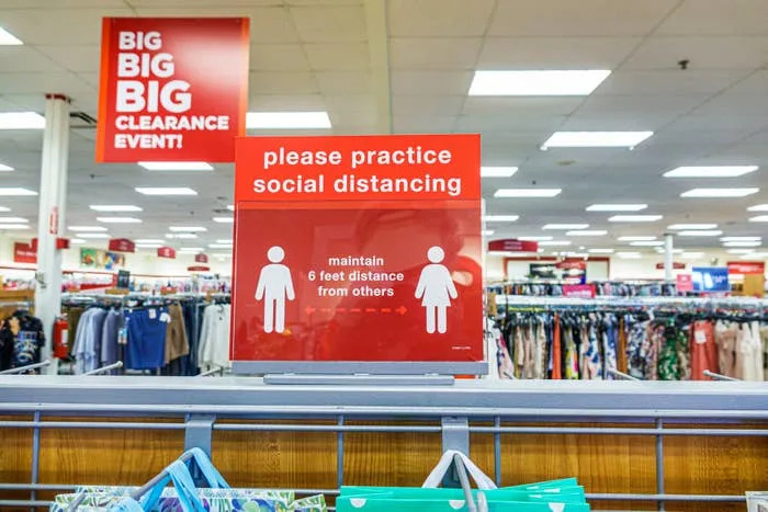 Store sign reminds customers to practice social distancing by maintaining a 6-foot distance from others