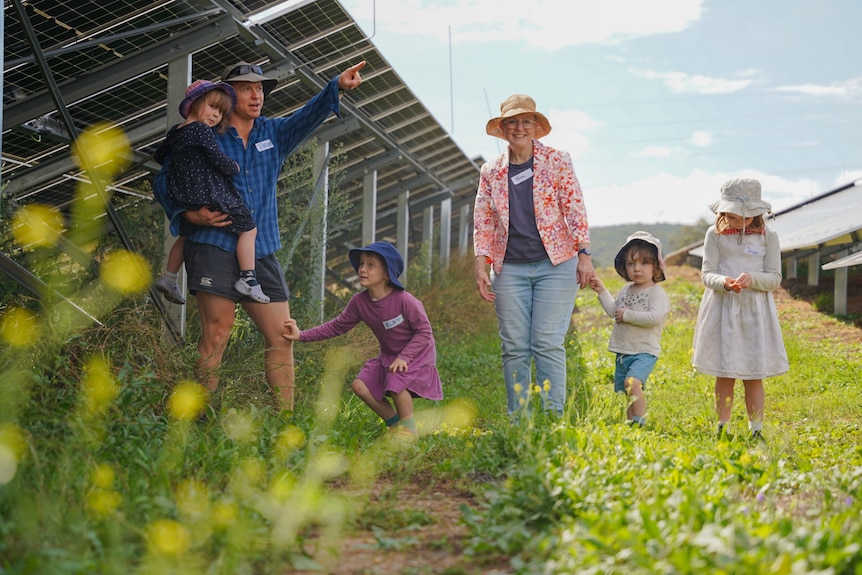 A young family of six in amongst solar panels