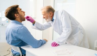 Doctor collecting an oral swab sample from a patient in a clinical setting for pulmonary tuberculosis testing