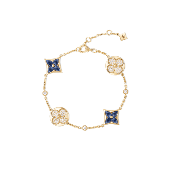Gold bracelet with blue and diamond floral motifs on a black background