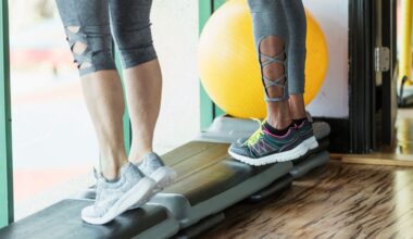 two pairs of legs stand on a workout step doing calf raises