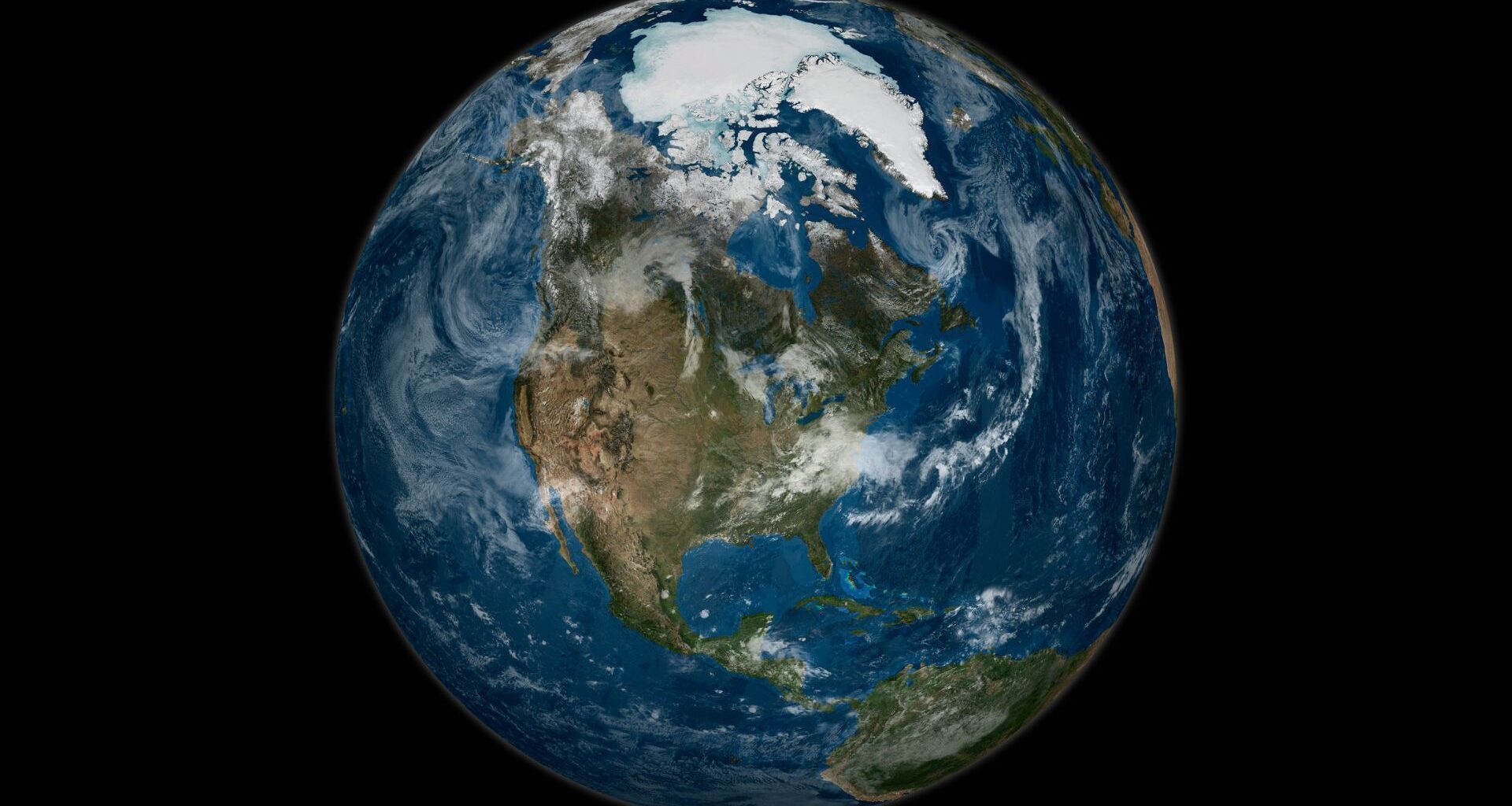 A view of Earth from space, with whisps of clouds drifting over the North American continent