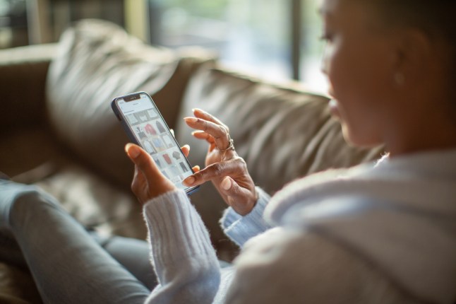 Woman shopping on a vintage clothes app from home