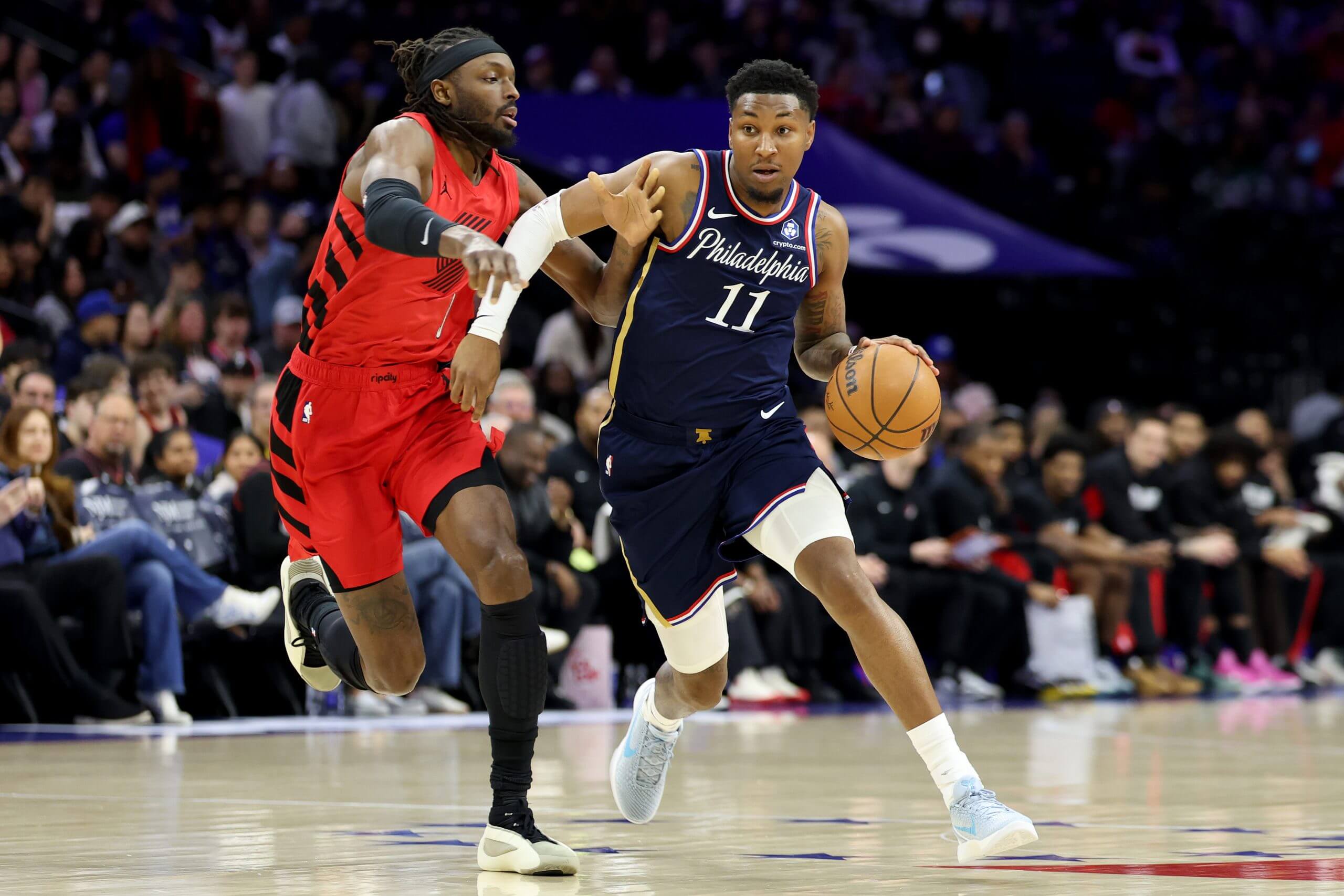 Justin Edwards of the Philadelphia 76ers drives past Jerami Grant #9 of the Portland Trail Blazers during the first half at Xfinity Mobile Arena on March 15, 2026 in Philadelphia, Pennsylvania.