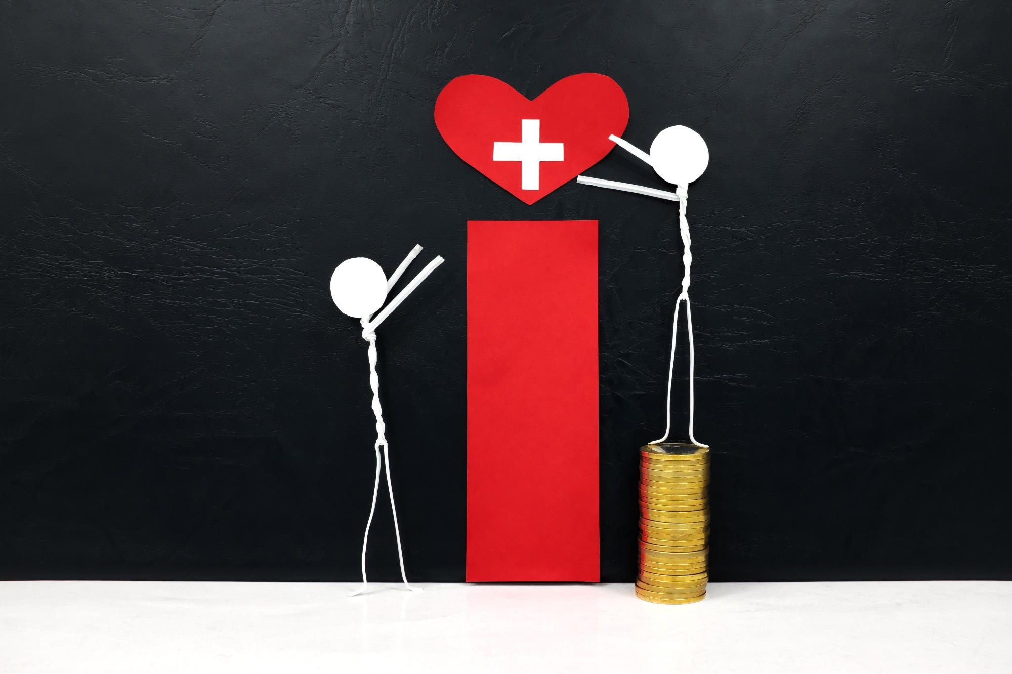 Stick man figure reaching for a red heart shape with cross cutout while stepping on stack of coins. Another stick figure not stepping on coins is unable to reach the heart
