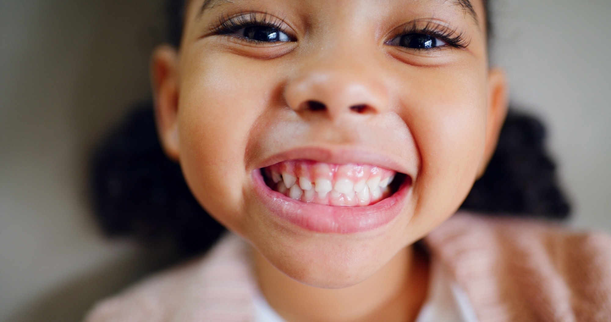 Close up of young girl with big grin showing her teeth