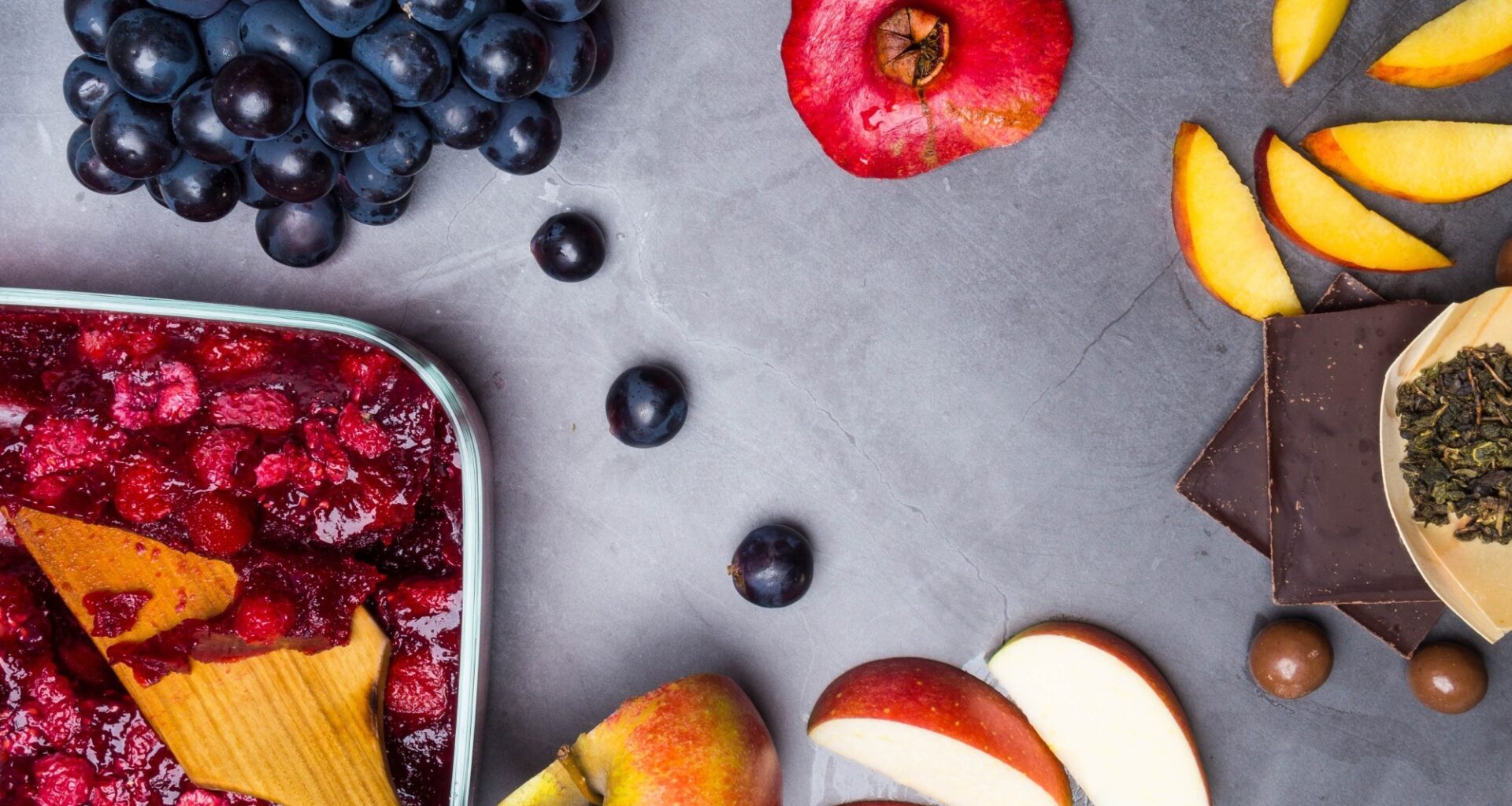 flavonoid rich food: apples, blueberries, raspberries on grey concrete