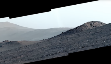 Rubies on Mars: View of hilly, barren gravel-covered terrain with mountains in the distance.