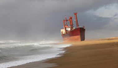 A large cargo ship stranded on a beach.
