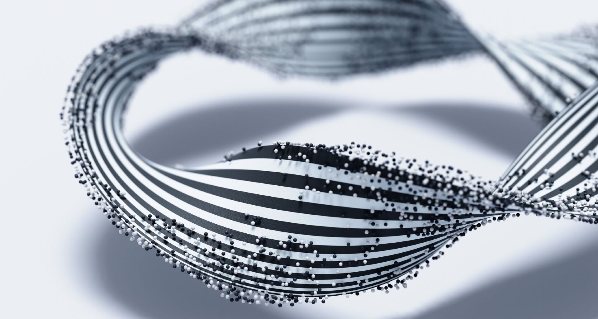 A twisted black and white striped ribbon is covered with small black and white dots against a white background