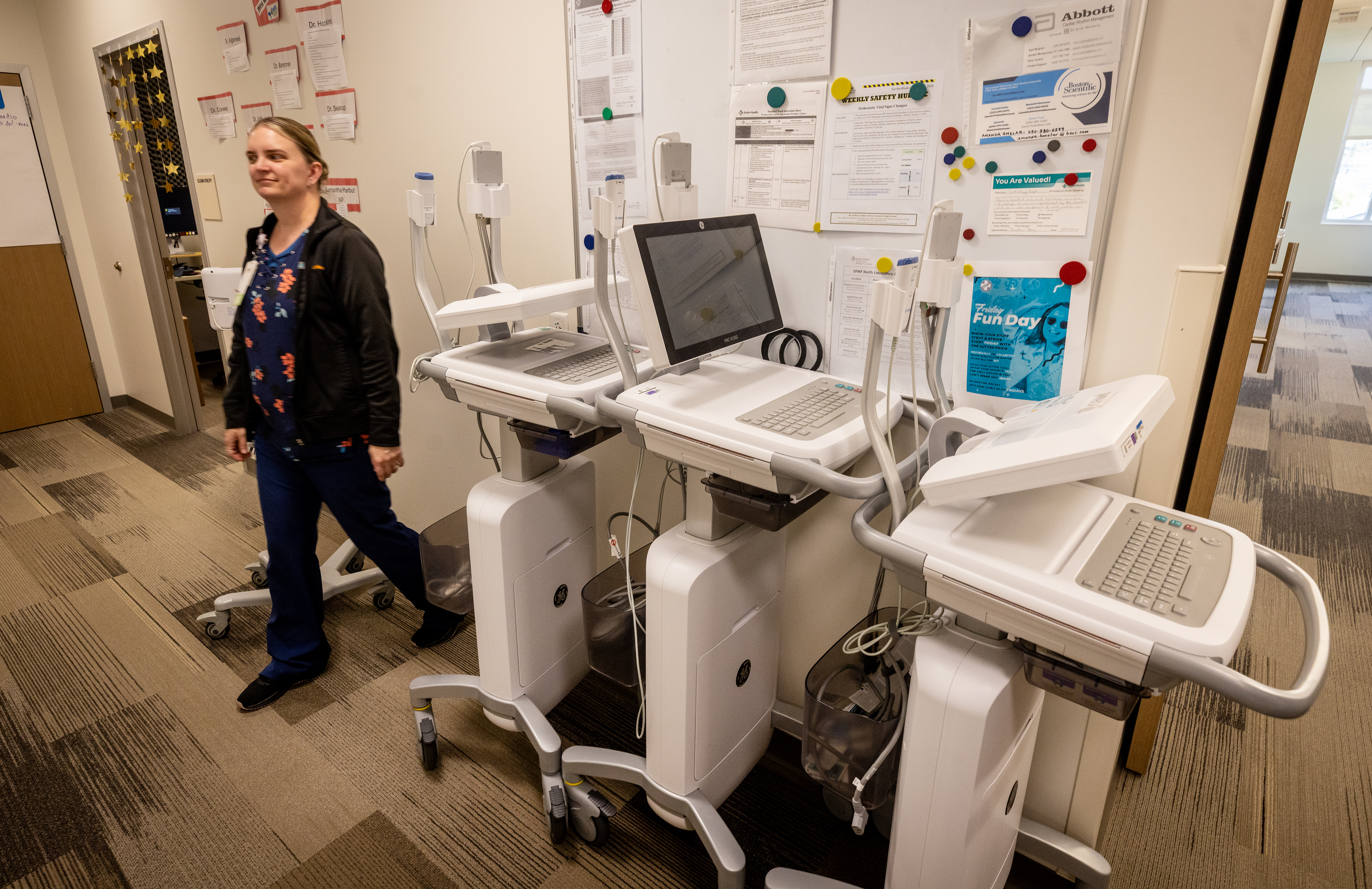 Sutter Health cardiology supervisor Keri Ashworth walks past EKG machines...