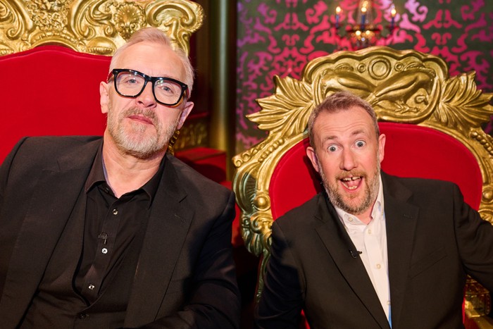 Close-up shot of Greg Davies and Alex Horne sitting in their Taskmaster thrones and looking at the camera. Alex has his mouth open in joy.