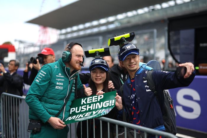 A team member of Aston Martin F1 Team poses for a photo with fans