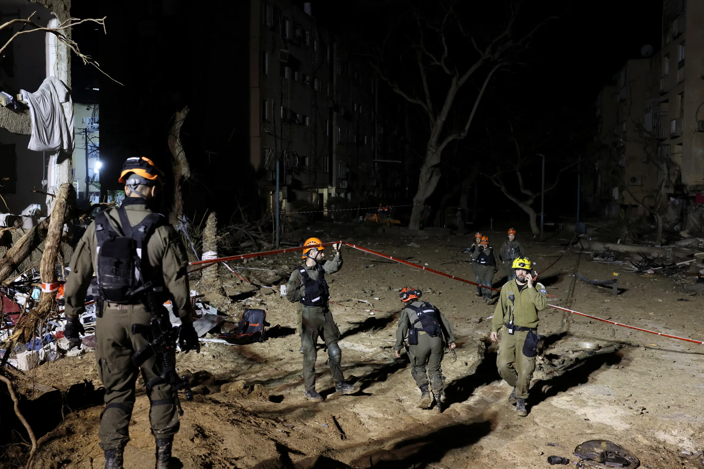 Israeli soldiers work at the scene of damage after Iranian missile barrages struck residential buildings in Arad.