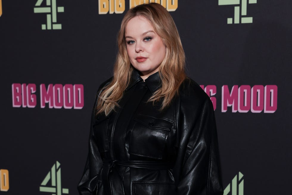 nicola coughlan on a red carpet at an event with promotional banners