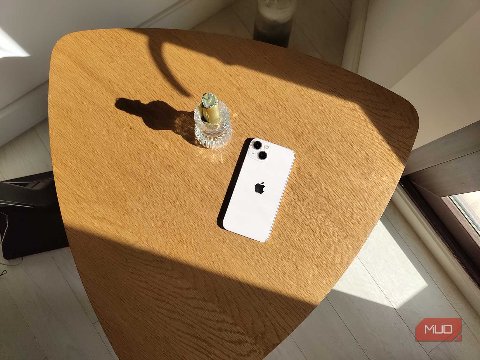 An iPhone next to a candle on a table shot on stock Android camera