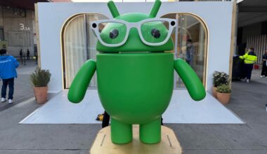 A green Android bot figure with smart glasses