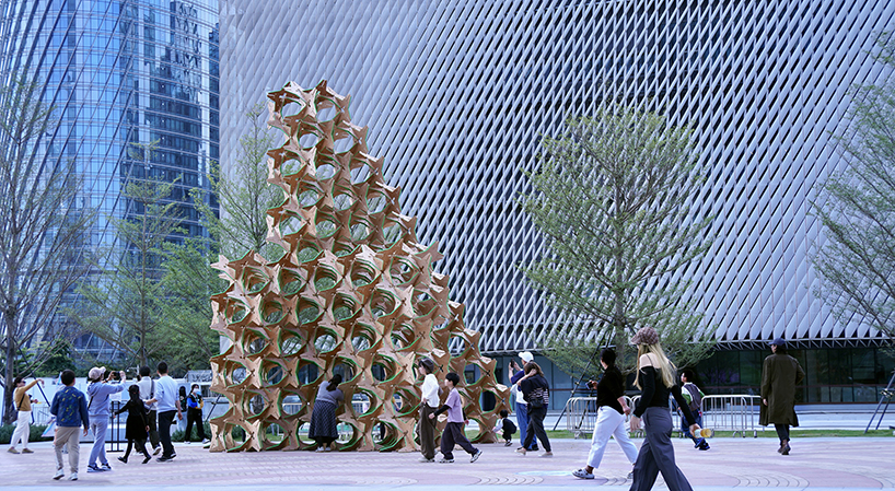hundreds of interlocking star modules build a porous timber installation - 2