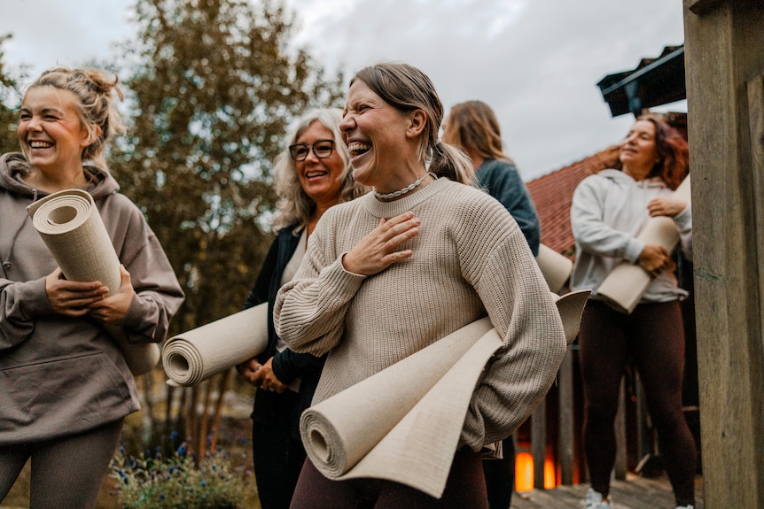 Group of happy women laughing after yoga class.