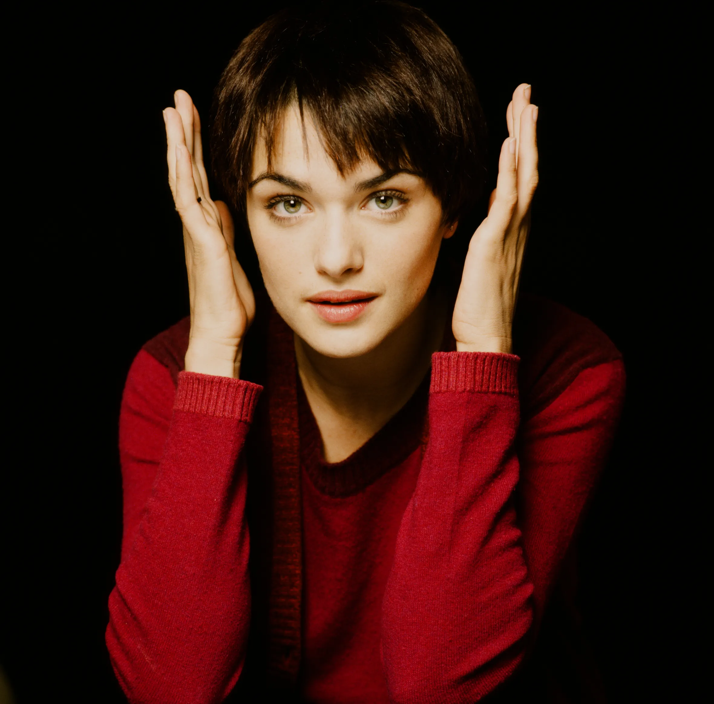 Rachel Weisz with hands framing her face.