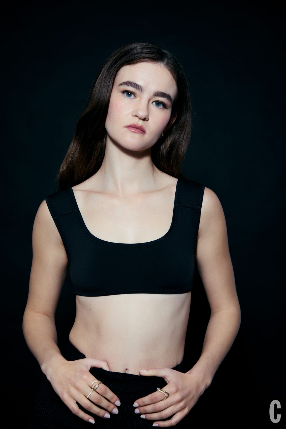 Model wearing a black bralette and black striped bottoms.