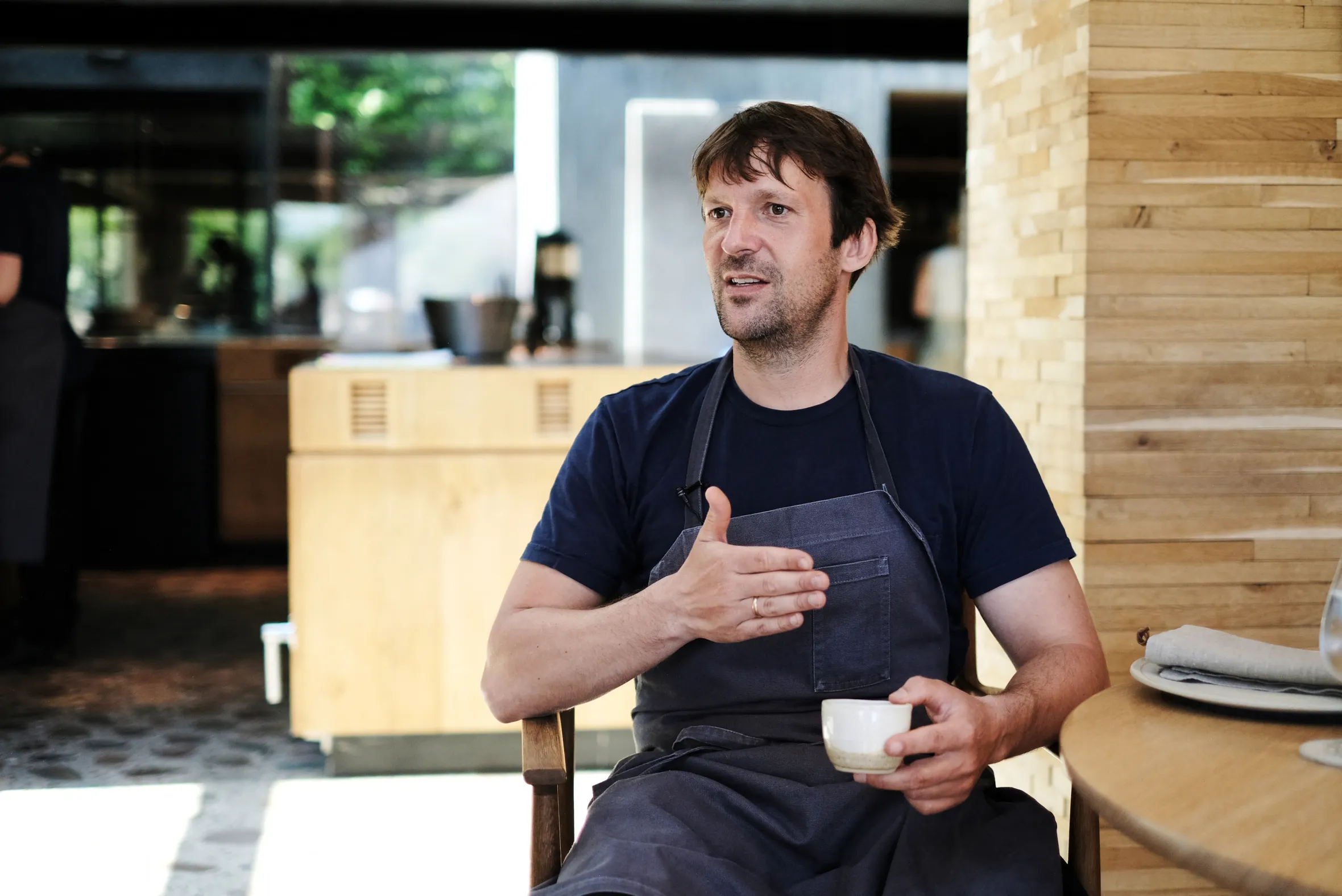 Rene Redzepi, chef and co-owner of the Danish restaurant Noma, sits while speaking with a white ceramic cup in his left hand.