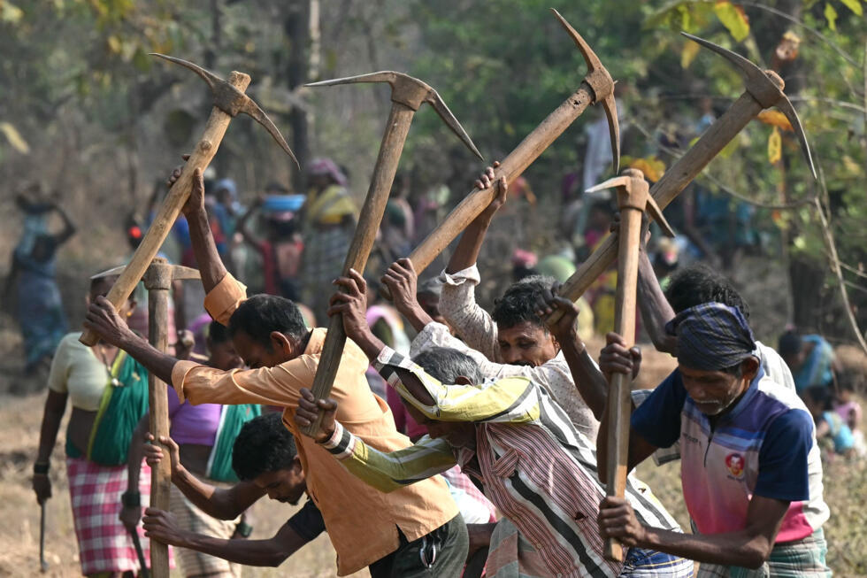 Wage-labourers under Mahatma Gandhi National Rural Employment Guarantee Act work at a road-construction site at Balapur Dolkarpada village in Maharashtra's Palghar district